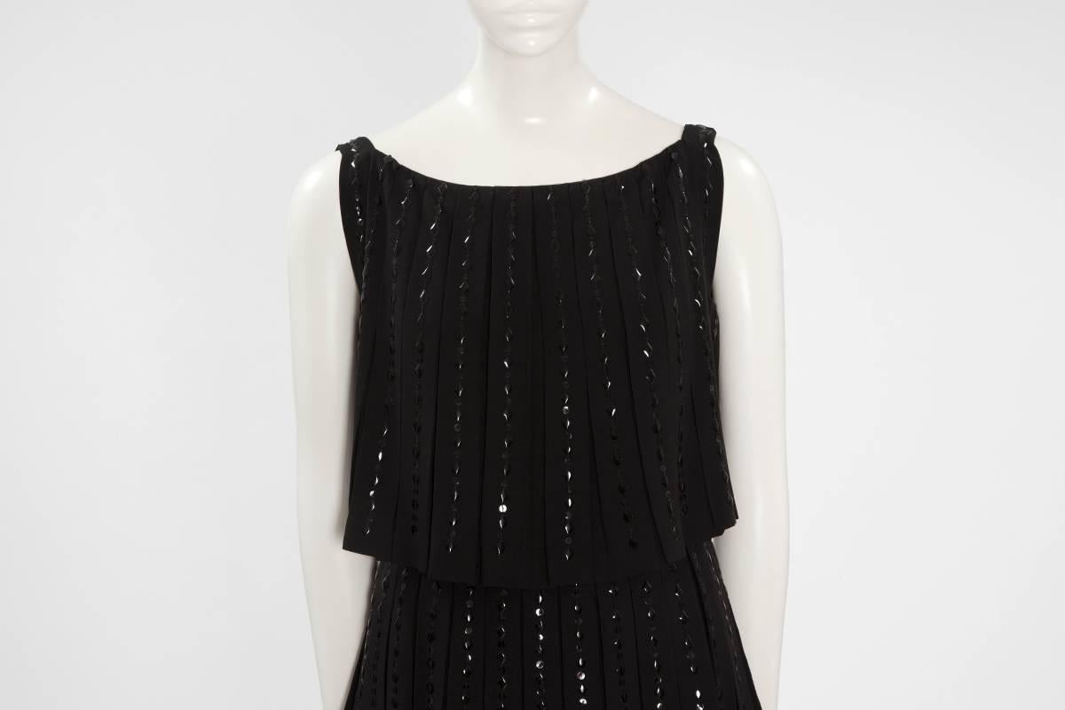 Abito da cocktail di fine anni '60 in lana nera con perline di Norman Hartnell, composto da tre strati plissettati che cadono in una graziosa cascata. Impreziosito da splendidi diamanti neri e paillettes rotonde nere, l'abito si chiude con una zip,