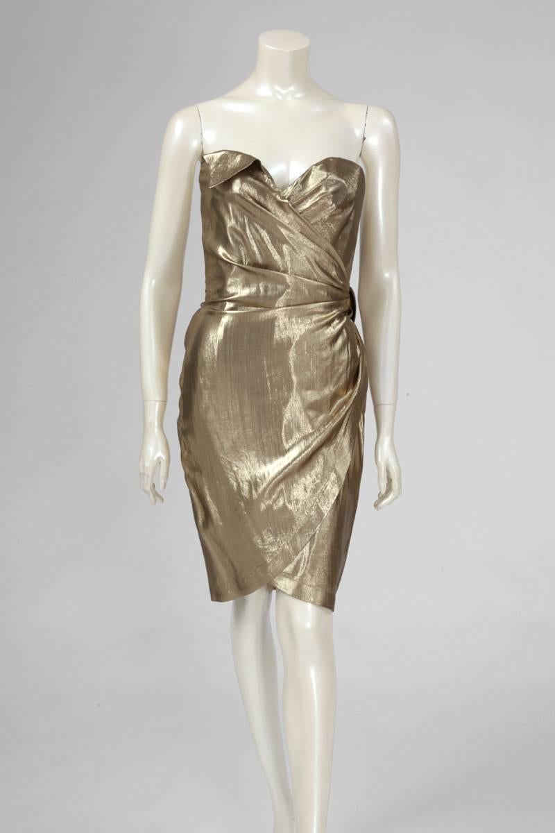 Late 80's - early 90's Thierry Mugler lamé strapless wrap dress with adjustable polished pewter buckle above the left hip closing a pleated belt. The dress is fully lined and the bodice is strengthened. Labeled a French size 38 (US 4-6), this piece
