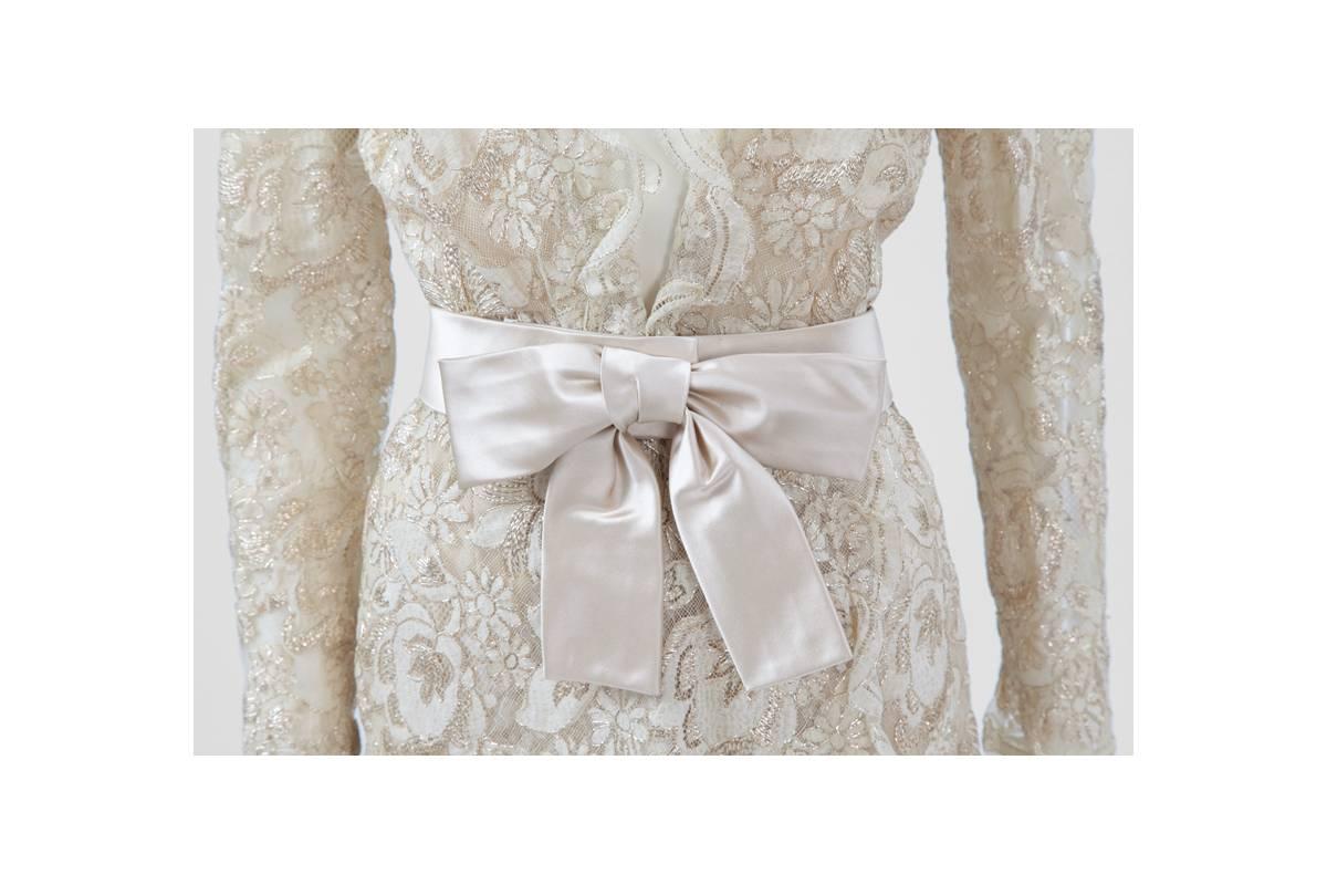 This 60’s “attributed to” Chanel haute couture dress is crafted from a soft ivory and gold floral lace with a plunging scalloped V-neckline. Falling elegantly just below the knee, the dress is cut for a close yet non-restricting fit and comes with a