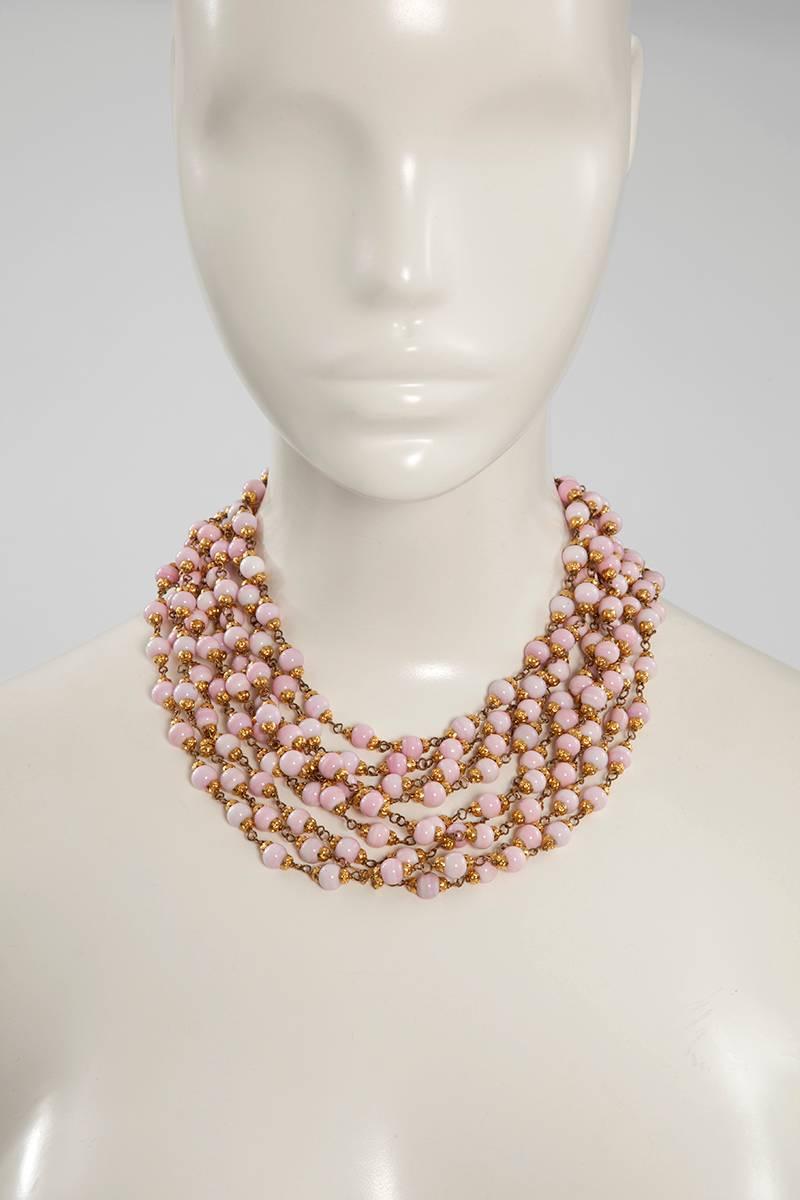 Mixing a ladylike effortless elegance with modern edge, this 1993 Chanel necklace has nine strands of faux Angel skin coral glass beads on gold-tone brass chains. An adjustable hook customizes the length. 

Dimensions :
Overall length (hook to