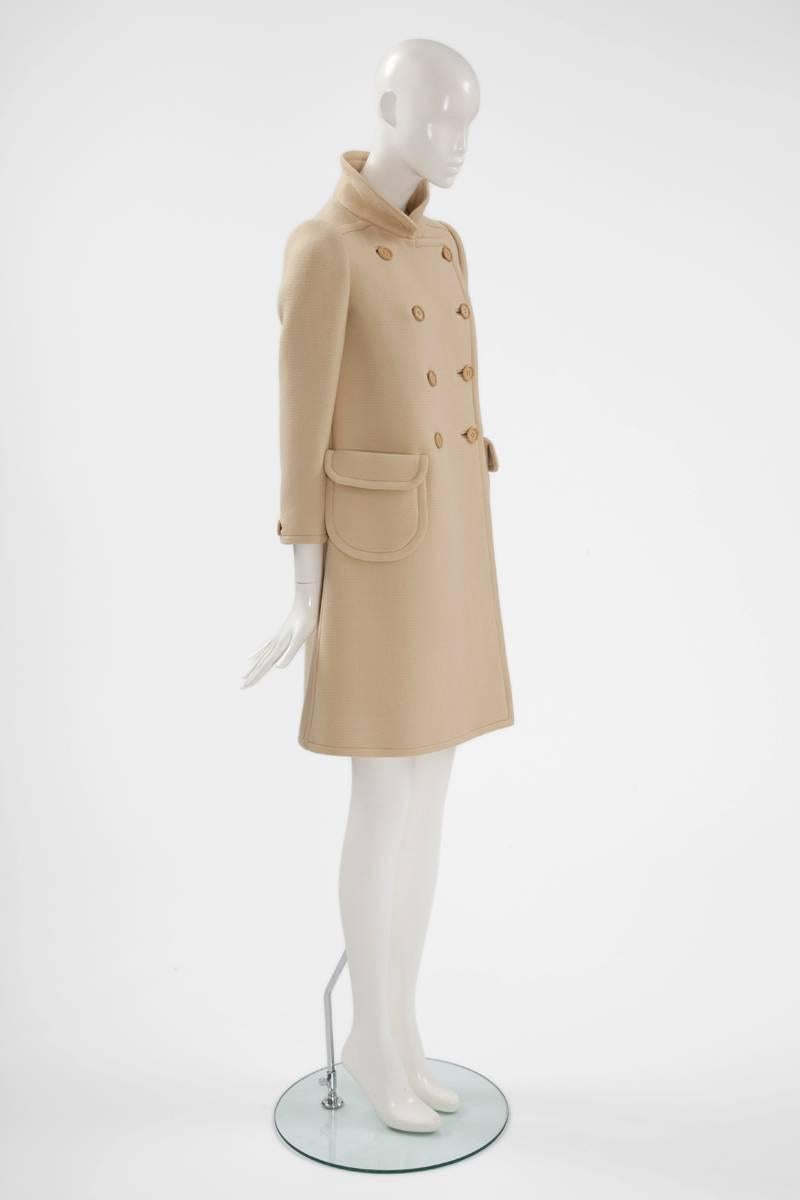 This wonderful numbered Courrèges haute couture coat is a fantastic timeless piece for spring, autumn and winter. Constructed in light beige wool gabardine, the classic 60s cut creates a flattering A-line silhouette. Featuring a Peter Pan collar,