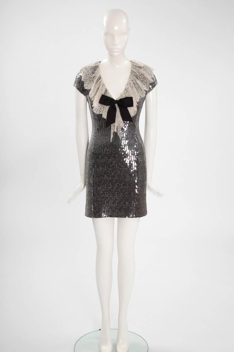 A marvellous choice for evening events, this rare Chanel circa 1987 figure-skimming mini dress is made from black silk georgette and embellished with hundreds of transparent sequins that catch the light from every angle. Chantilly lace collar and