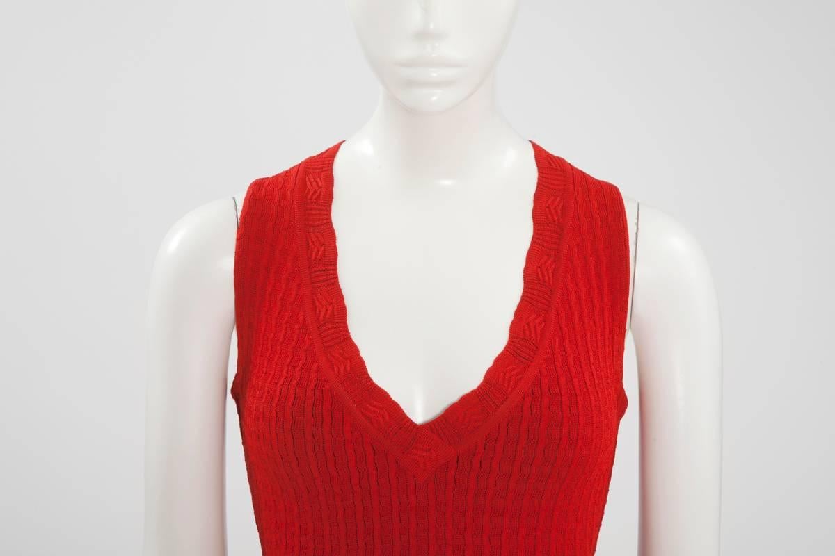 Vibrant 1992 Alaïa red viscose knit dress with semi sheer crochet-work detail. Unlined, this piece nips in at the waist, features a V-neckline and has hidden snap closure shorts under the skirt (see pictures 5 & 9). The dress closes with a zip in