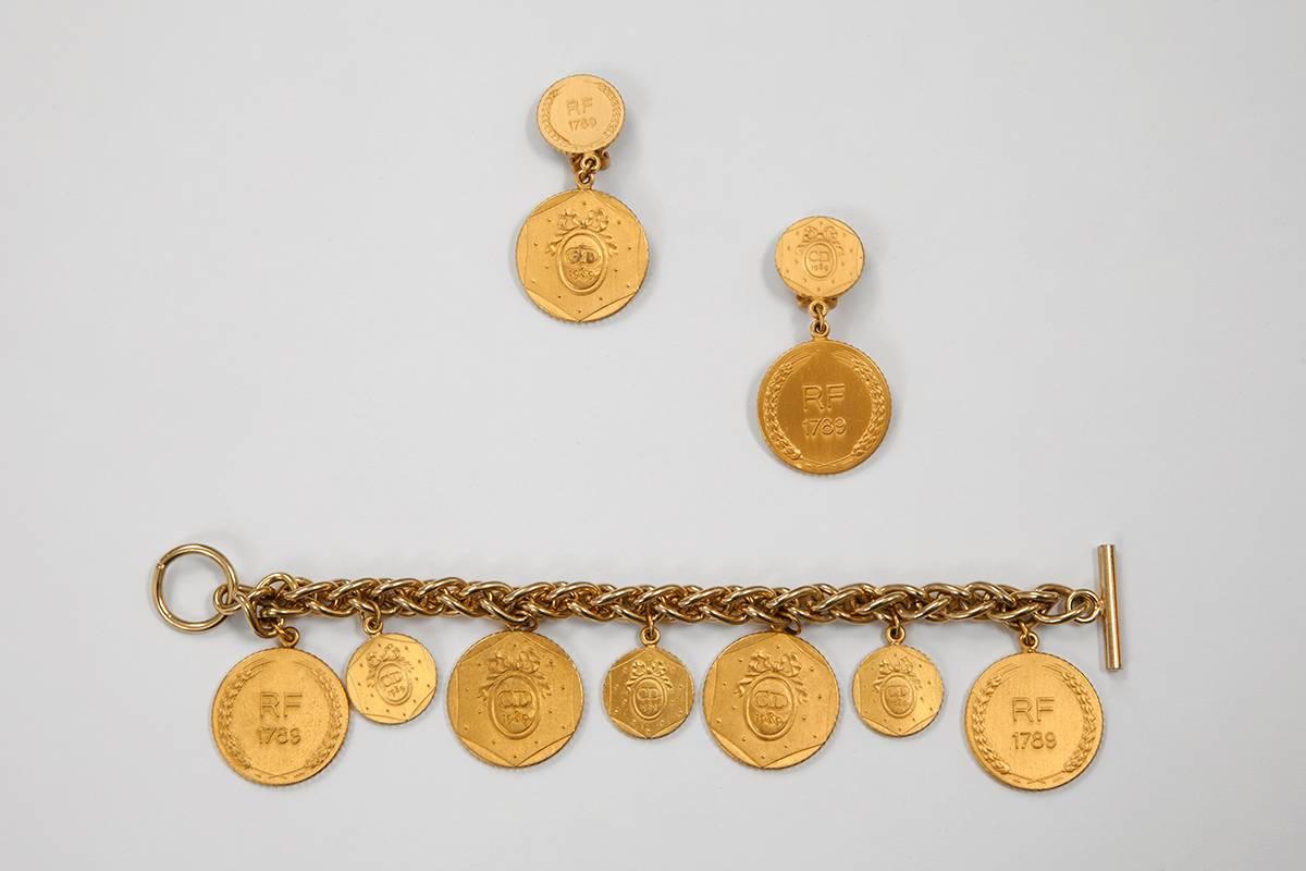 Collectible vintage Christian Dior gilt metal charms medallion bracelet and matching earrings, created for the bicentennial commemoration of the French Revolution. Each medallion features the classic Dior logo with 1989 inscription on one side and