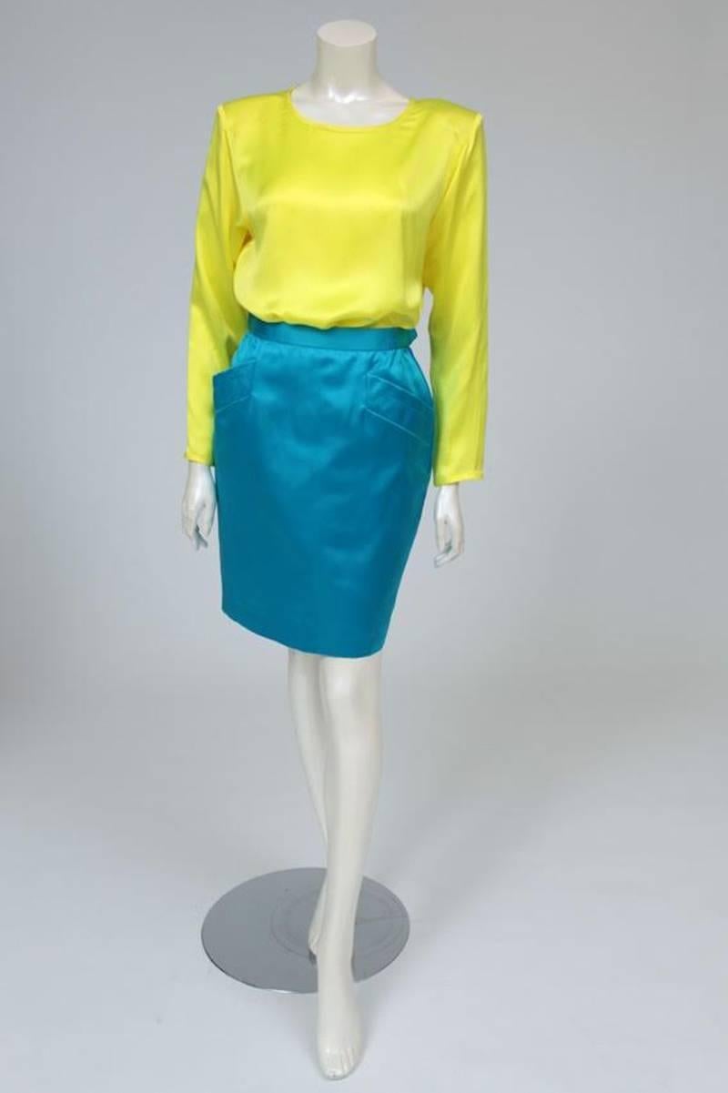 Inject a touch of neon blue color into your wardrobe with this stunning early 80's Yves Saint Laurent skirt. Constructed from refined silk satin, the skirt sits high on the waist for a flattering silhouette. Featuring two large pockets on the hips
