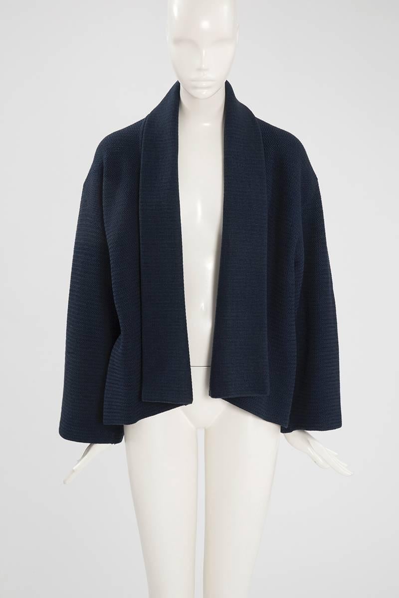 This unusual and rare Alaïa kimono inspired jacket dates from the late 80’s - early 90’s. Constructed in dark blue wool knit, the jacket can be either worn open or closed thanks to its matching leather belt.  Unlined, the jacket is a size small
