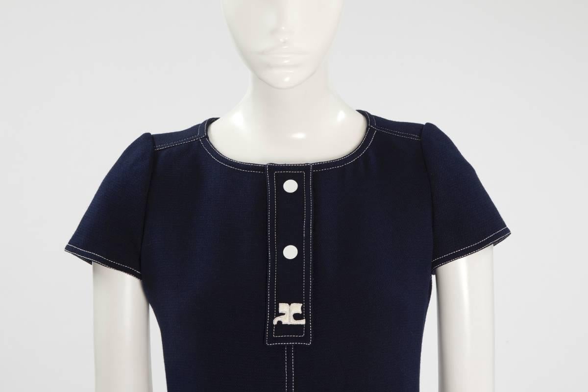 This ultra chic late 60’s - early 70’s Courrèges suit is made up of a fitted tunic-top and high waisted trousers. Constructed in dark blue wool with contrasting white topstitching, the fully lined short sleeves round neckline tunic is closing,