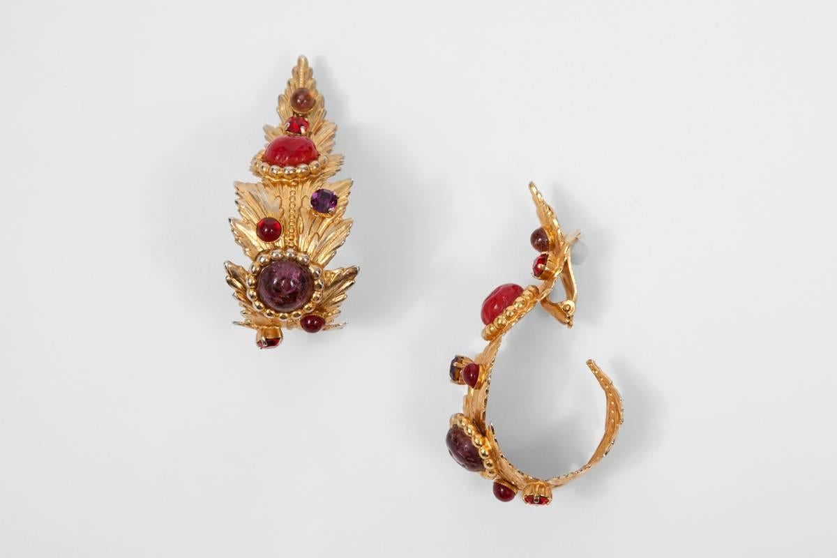 Created by the famous French jewelry designer Dominique Aurientis, these signed 80s gilt metal earrings are beautifully shaped as large curled baroque leaves. Amethyst and rubis-like poured glass cabochons and matching rhinestones enhance these