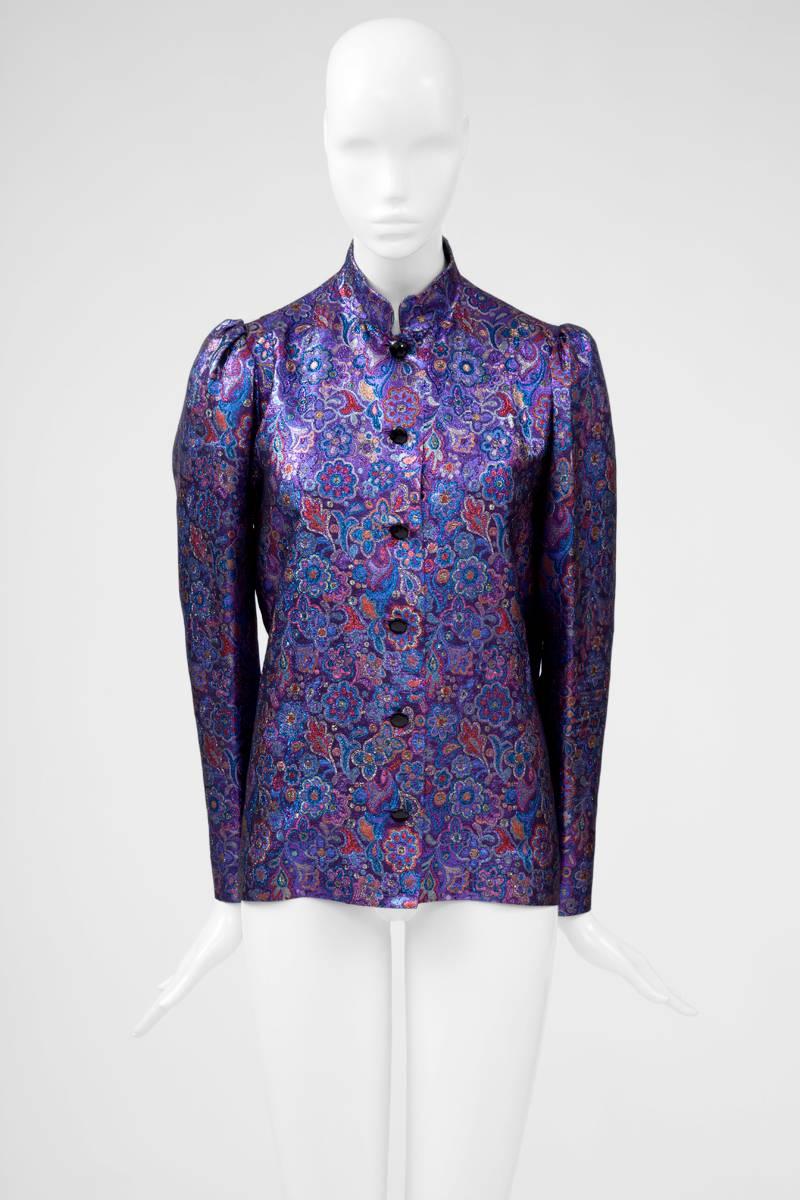 This true haute couture treasure from the late 80’s - early 90's is cut in vibrant purple silk-blend lamé with red, blue and silver leaf and floral pattern. Unlined (except in the shoulders areas), the blouse fastens with six black faceted buttons