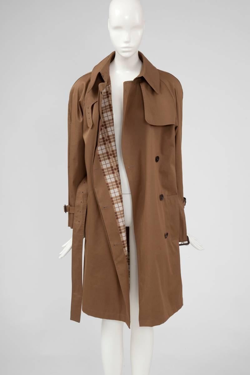 Back to basics with this Fall-Winter 2009-2010 Hermès trench coat by Jean Paul Gaultier. New with tags (see picture 9), this timeless piece is cut from a tobacco beige cotton gabardine and fully lined with a checkered matching fabric. Featuring all