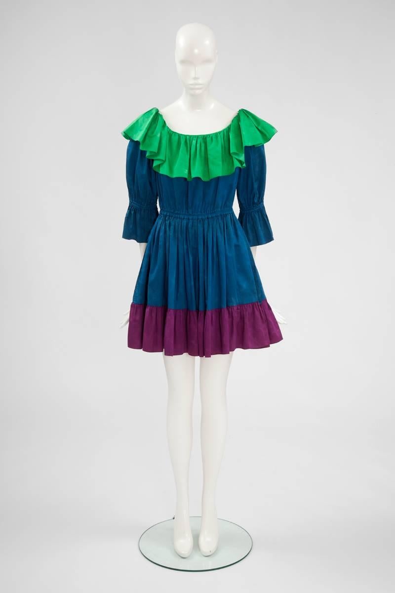 Constructed in an elaborate cotton that provides a subtle tie-dye effect (see picture 9), this three colors playful YSL summer dress depicts an exaggerated ruffle collar, which can be worn off or on the shoulders. An elasticated waist features