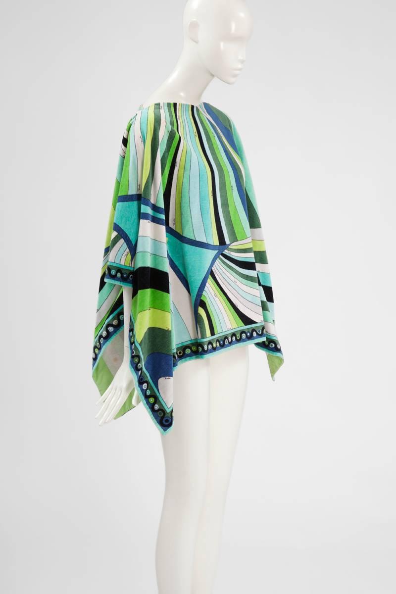 Perfect for several beach breaks, this rare 60’s coverup features the signature psychedelic Pucci print that mixes various shades of turquoise, blue and green with black and white. Constructed in cotton towelling, it fastens with eight inside snaps