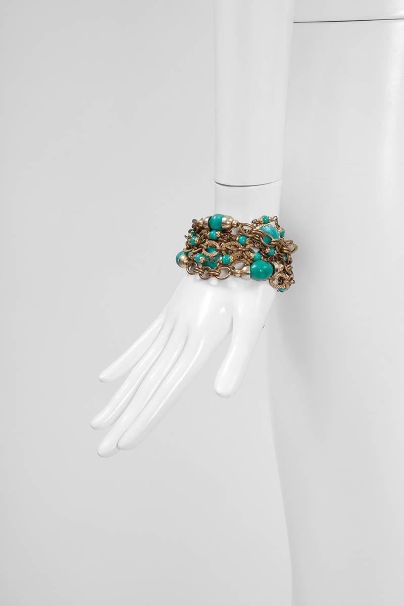 Made of ten strands of gold-tone chains and various shape and size faux turquoise glass beads, this rare vintage Chanel bracelet closes with an adjustable hook which enables length adjustment. Matching earrings available in another listing.