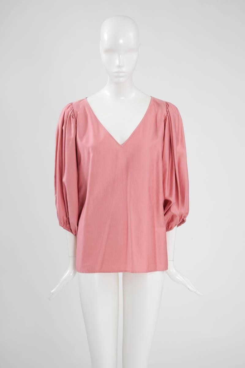 Late 70’s Yves Saint Laurent Rive Gauche gypsy blouse. Constructed in antique pink satin cotton, the tunic features three-quarter full sleeves that gather at the shoulders. Elasticated cuffs. Flattering V-neckline. Labelled a French size 38 (US