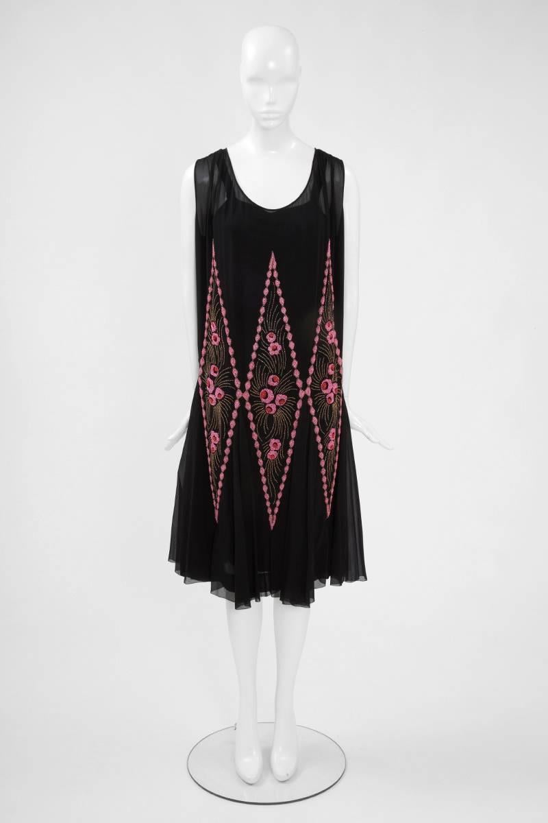 Crafted in black silk chiffon, this exquisite floral pattern flapper dress is embellished with pink, red and bronze glass beads. The work is entirely hand-made and provides a three-dimensional effect. As the beads are rather heavy, they make the