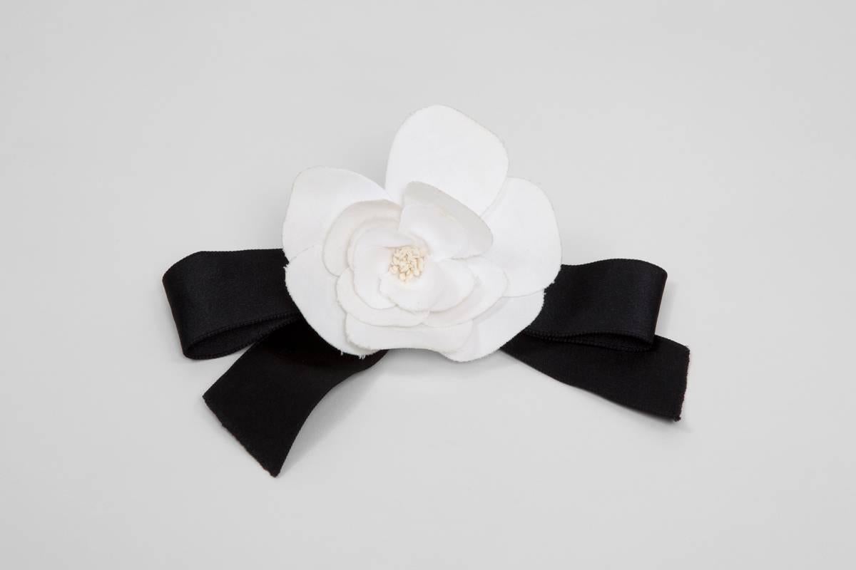 Vintage black satin bow ribbon with a delicate off-white silk camellia. A forever timeless Chanel piece, easy to style with nearly everything, from a LBD to a cotton shirt !

Dimensions : 
Max length approx. 16.5 cm (6.5 inches)  
Max width approx.