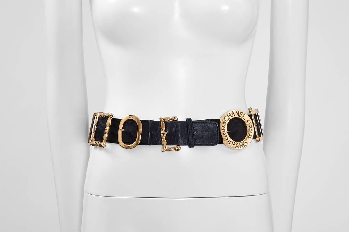 Rare 90’s Chanel find, featuring gilt metal belt buckles of various shapes and sizes on a large black elastic and leather belt. Stamped on the leather on the reverse 