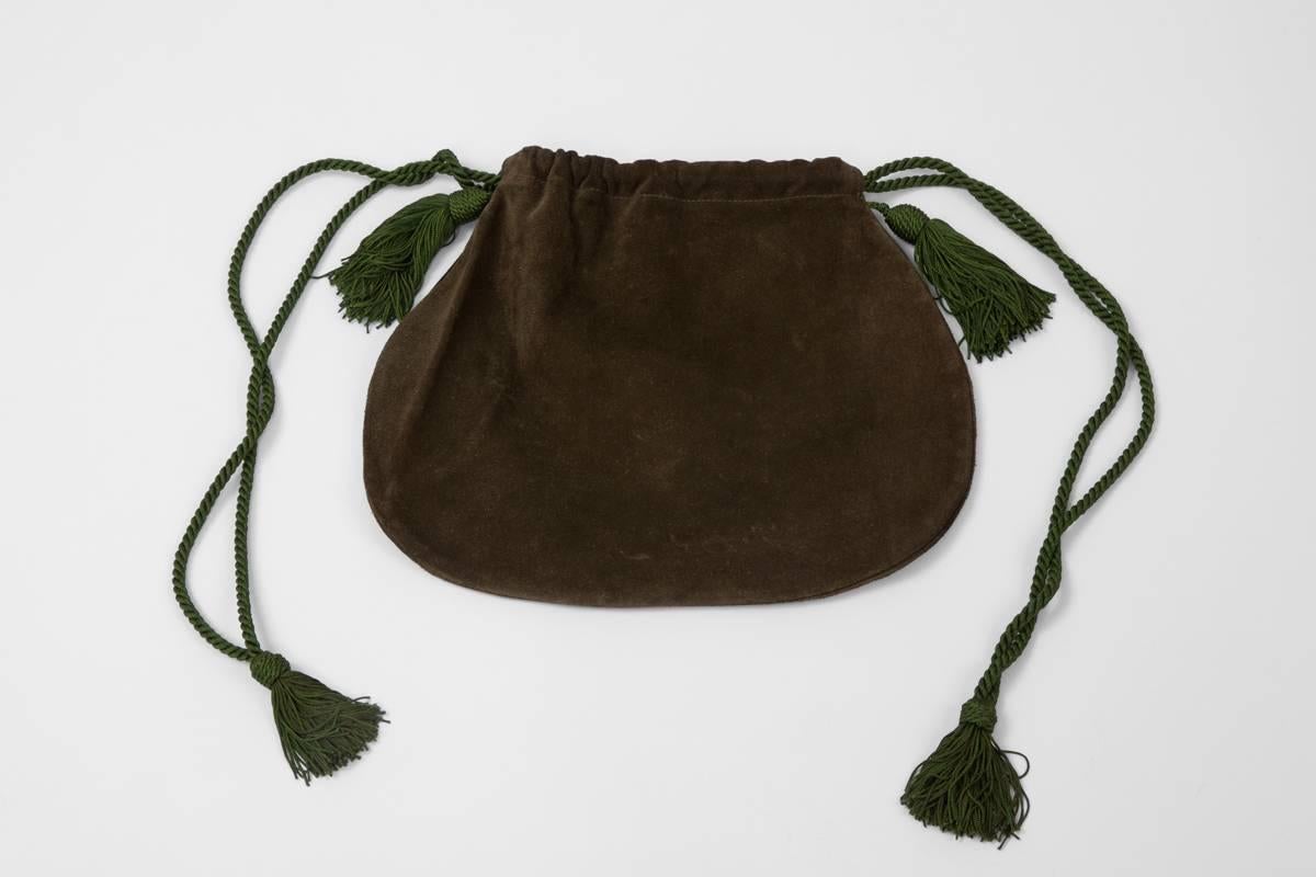 Perfect for fall and/or a weekend in the countryside, this adorable signed khaki suede YSL drawstring bag dates from the 70’s. Refined trimmings shoulder straps with four tassels.

Dimensions (approx.) : 
L 29 (at the longest) x W 0.7 x H 24.5 cm /