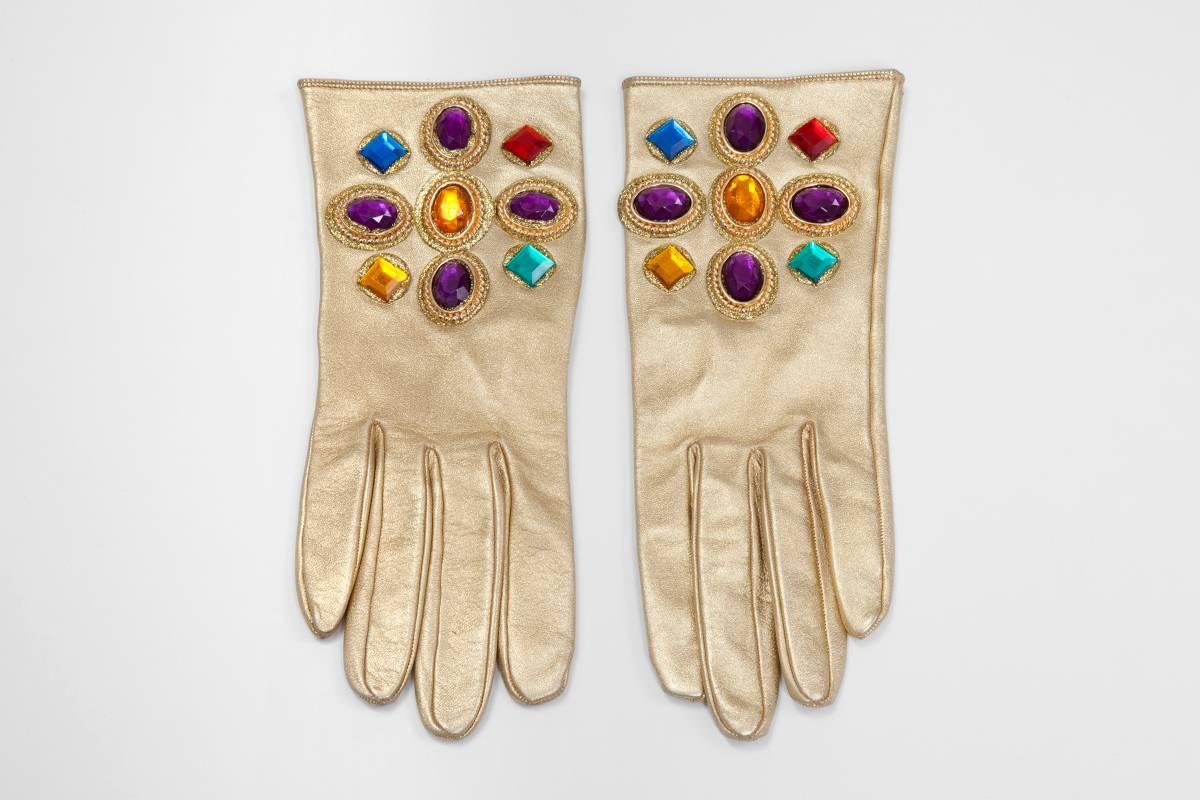 Keep your hands warm and chic with this fantastic, never worn, vintage Christian Lacroix gloves. Crafted in France in golden leather embellished with faux gemstones (ruby, emerald, citrine & amethyst), the pair is fully lined with silk for a