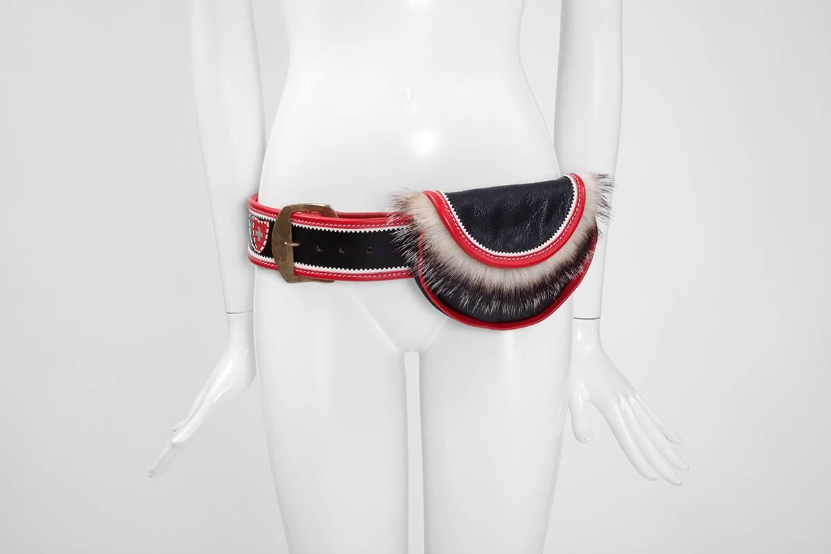 This 90’s cult accessory is again an absolute fashion trend nowadays. Crafted from solid black, red and white leather, with a large metal buckle, this vintage belt bag will be a perfect and original addition to any mountain resort look ! While the