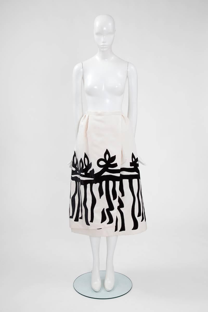 This Christian Lacroix asymetrical skirt will look equally great with a relaxed jumper or an evening top. Constructed in off-white silk faille, the piece sits high on the waist then flares out to a full structured midi-length hem. Black velvet