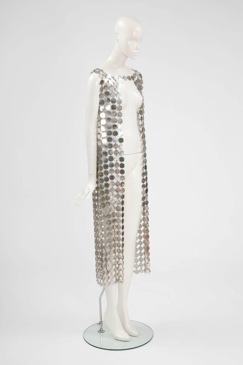 Remarkable example of Paco Rabanne’s iconic aesthetic, this early 70s long cardigan is constructed of chainmail style fabric, made up of silver rhodoïd discs joined together with matching silver plastic straps. This unlabeled piece is completely