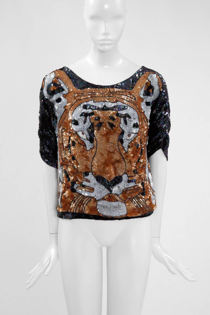 Thanks to Gucci, feline motifs are nowadays very desirable. In order to embrace the season’s “more is more” trend, this 70’s sequined tiger disco top is the perfect striking eveningwear ! Totally covered in glistening sequins and beads, this