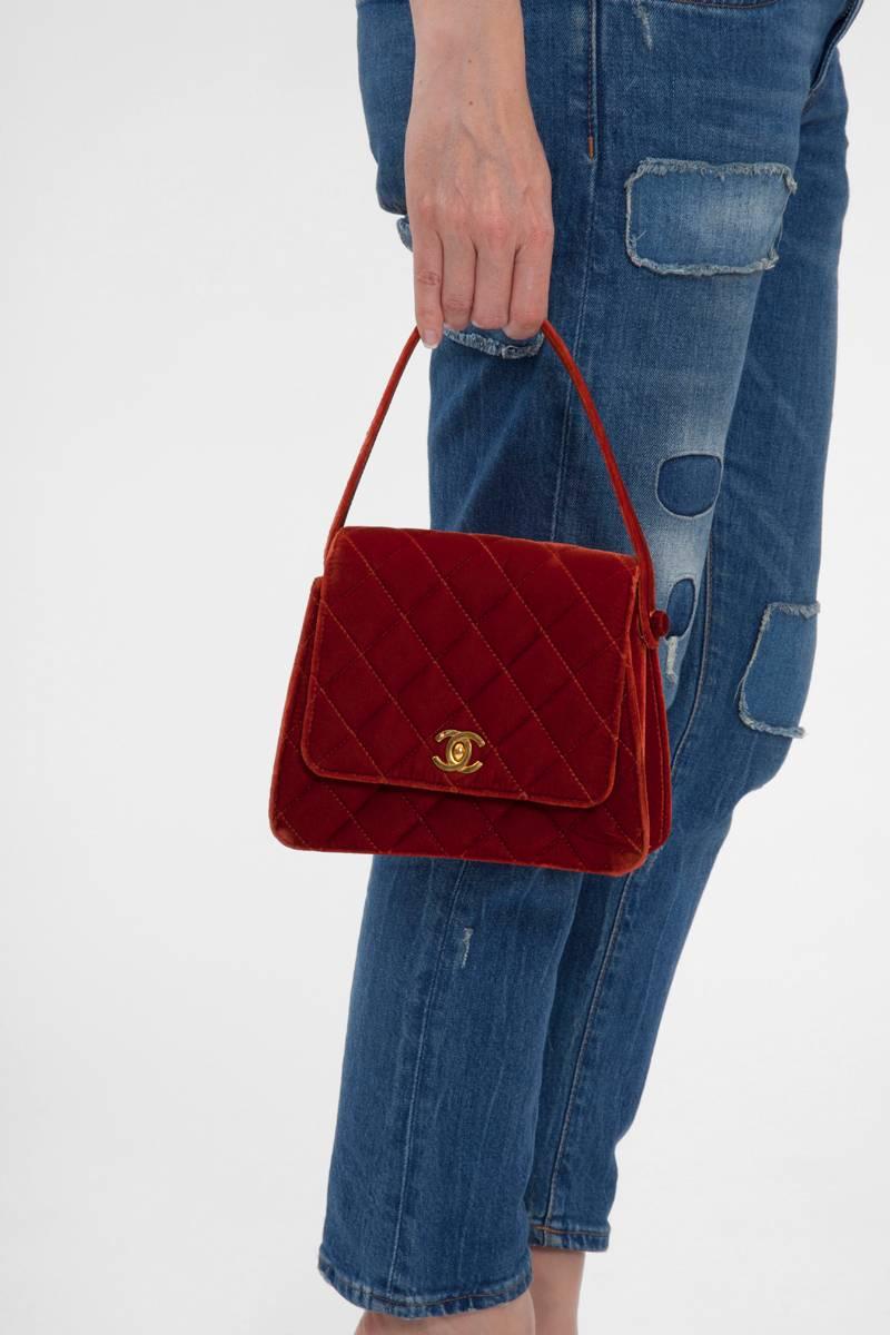 Diese hinreißende Vintage-Handtasche von Chanel fängt ein gewisses Gefühl zeitloser Eleganz ein und ist aus Samt und goldenen Beschlägen gefertigt. Kein anderer Stoff verstärkt die Farbe so gut wie Samt. Deshalb sieht die Rostfarbe dieser Tasche so