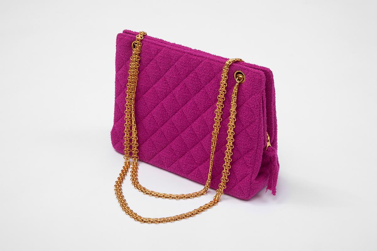 From the iconic SS1994 runway collection, this hardly worn Chanel shoulder bag is crafted from bright fuchsia « bouclé » tweed and features gold hardware. Fully lined in a refined matching « gros-grain » silk, this structured piece has two interior