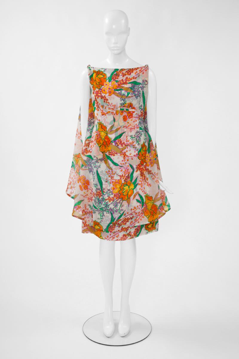 Dieses ärmellose Haute-Couture-Cocktailkleid von Nina Ricci mit seinem raffinierten, mehrfarbigen Blumenprint aus Seide eignet sich perfekt für eine Hochzeit oder eine Taufe. Das Kleid hat eine A-Linien-Silhouette mit einem Schleifendetail auf der