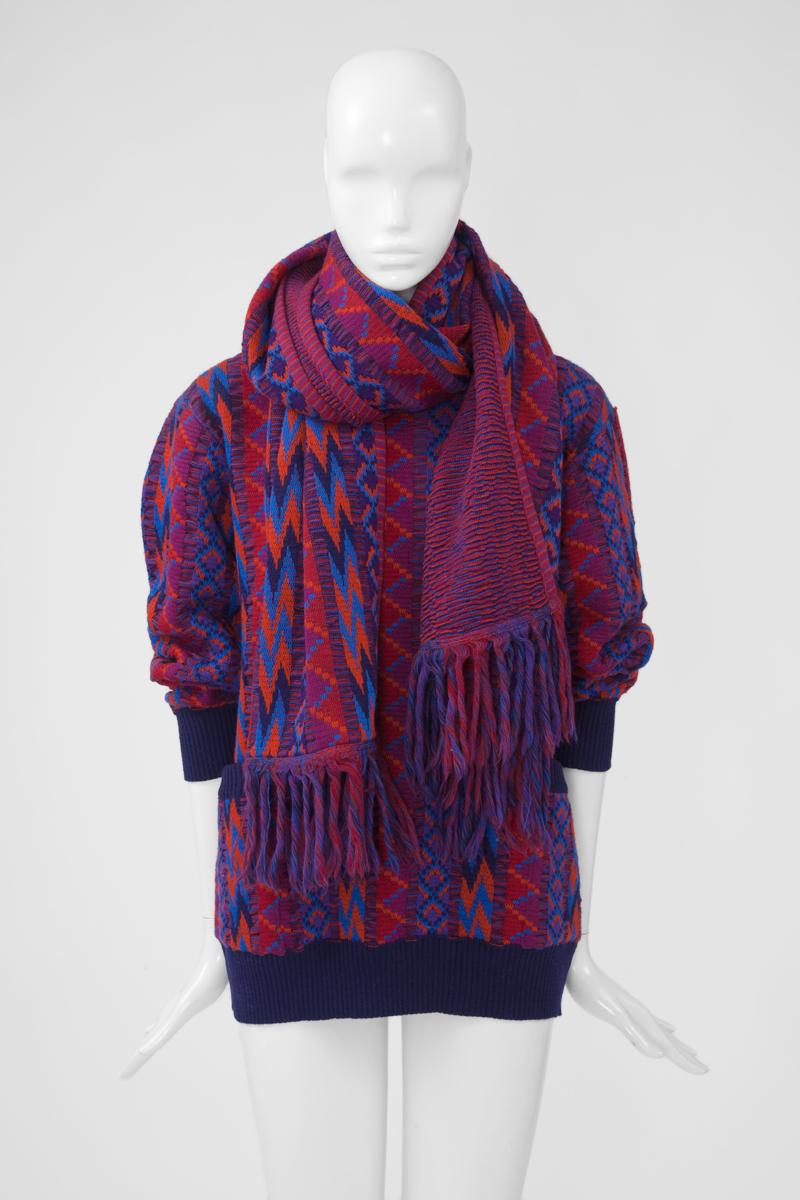 Dieser YSL-Laufstegpullover FW1982-1983 (siehe Bild 10) mit buntem Muster und passendem Schal ist perfekt für die Herbstsaison. Der Pullover aus Wolle hat einen gerippten Halsausschnitt, Saum und Manschetten sowie zwei Taschen. Tragen Sie den