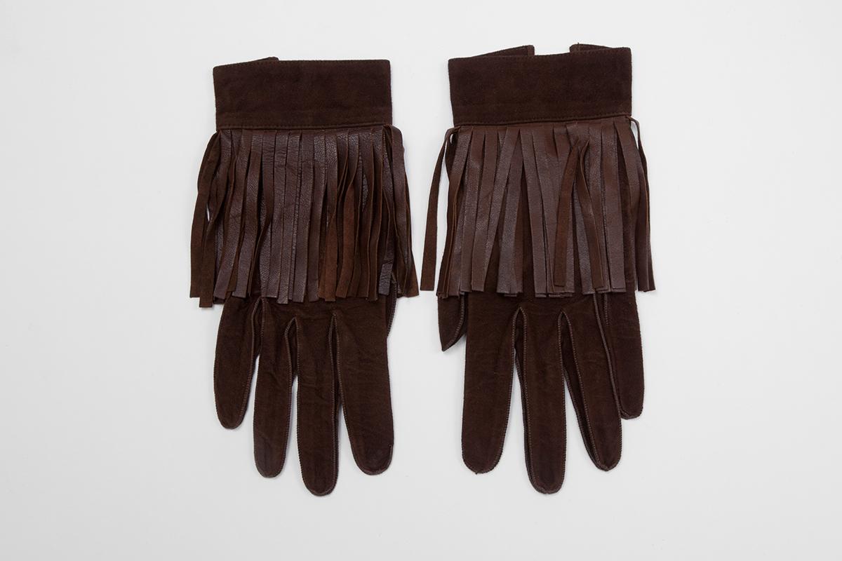With a touch of quirky elegance, these YSL fringed dark brown suede vintage gloves are of size 7.5 (approx. size M). Longest length (middle finger) is approx. 23.8 cm (9.4 inches). Unlined, the interior is in leather. Fringe length approx. 9.4 cm