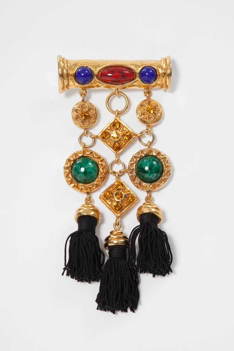 Unusual large 90's signed Christian Lacroix brooch. Colorful faux lapis lazuli, malachite and red marble combined with yellow rhinestones in a gold-toned setting together with tree black silk tassels. To be worn casual on a military jacket or smart