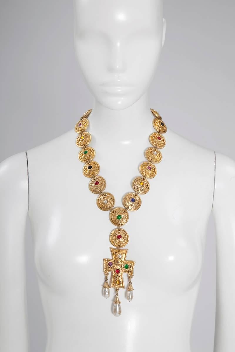 Unsigned Byzantine revival necklace featuring massive textured gilt metal disc and cross with colorful faux stones. Tree important faux Baroque pearls ornate the foot and arms of the cross. Adjustable fastener.

Dimensions approx. :
Disc diameter