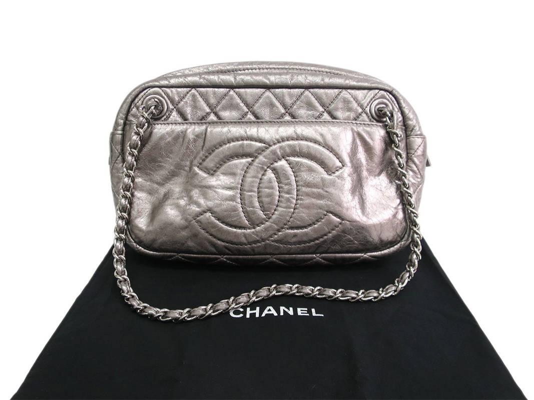 This piece comes complete with original Chanel dustbag. Silver chains and hardware are shiny without tarnish or oxidation. Some superficial scratches present on the exterior leather. Features 2 exterior slot pockets. There is 1 inner zippered