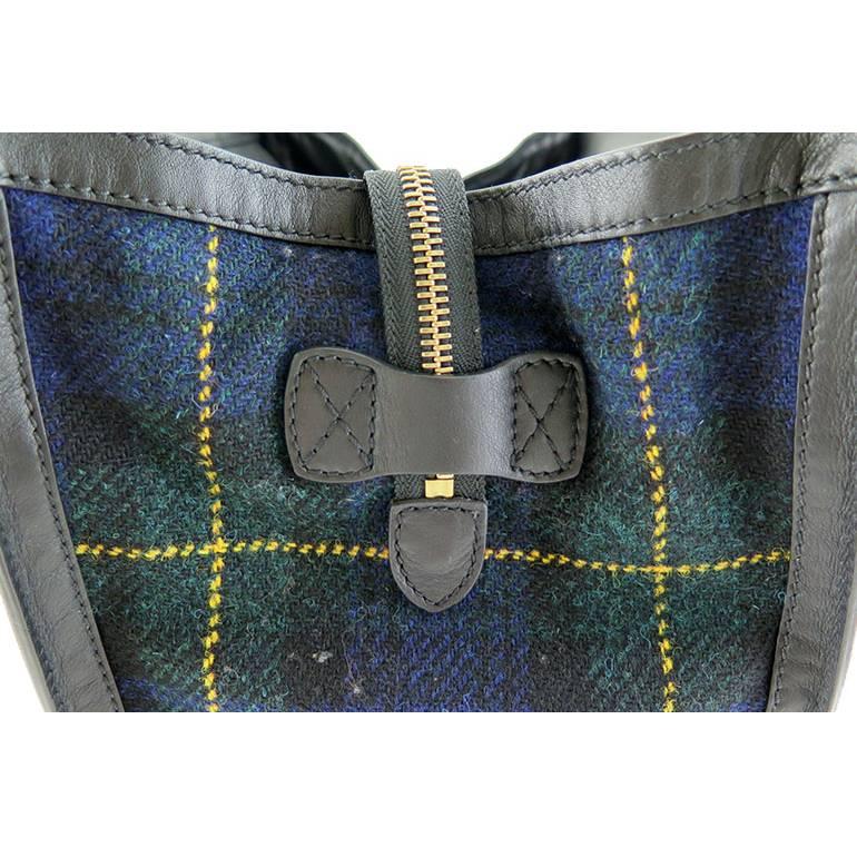 Rarely available in bi-fabric combination. This was a seasonal piece from the fall-winter collection. It is in excellent condition without stains on the tartan tweed fabric and no visible scratches on the black calf leather. Handles stand upright.