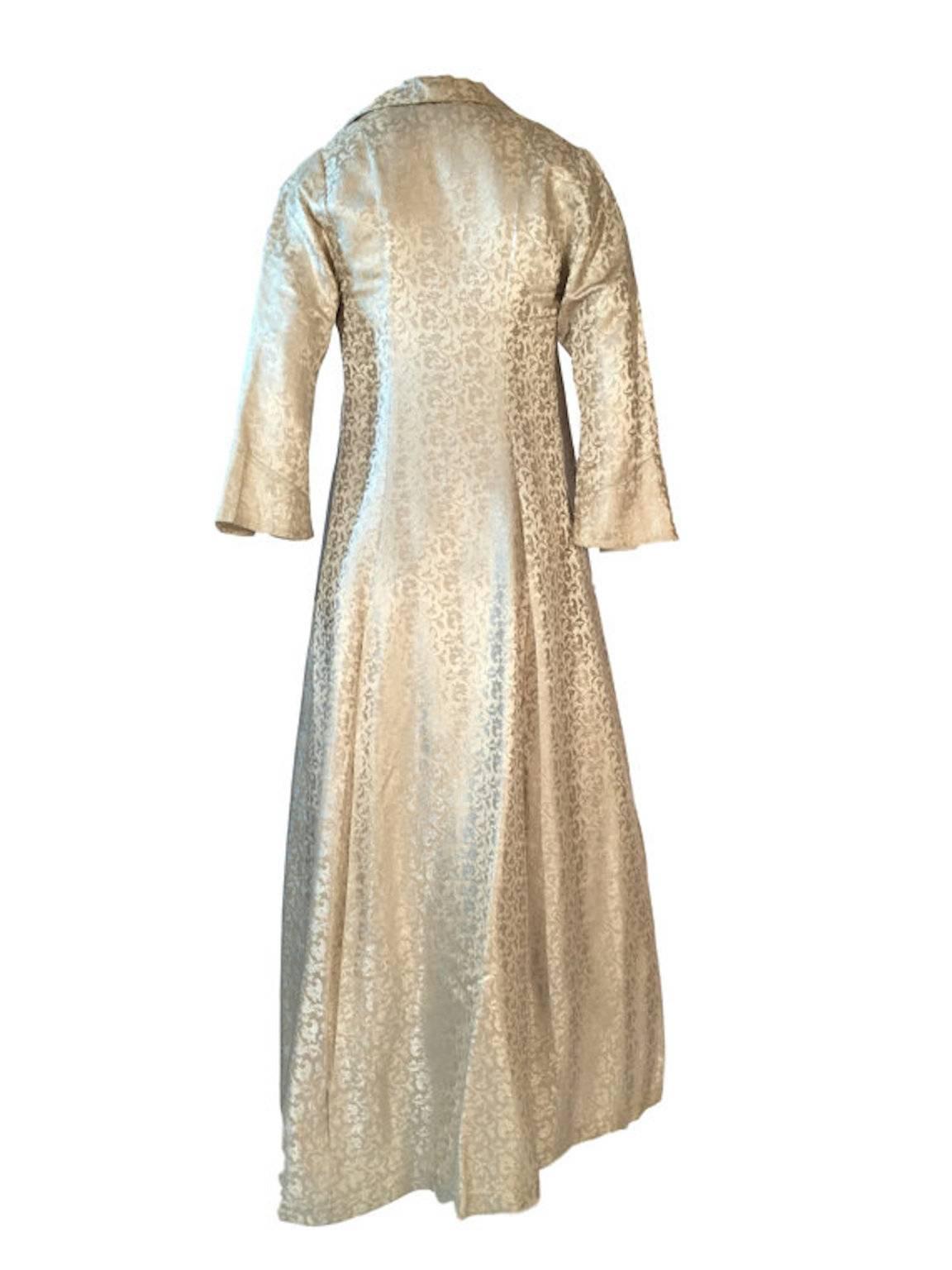 Thea Porter Made In France Cream Satin Damask Evening Coat. Paisley design silk maxi coat, made in the 1970s, has one button front fastening, relaxed fit from waist, fitted slightly flared cropped sleeves.

Size UK 8, measuring 16 inches across bust