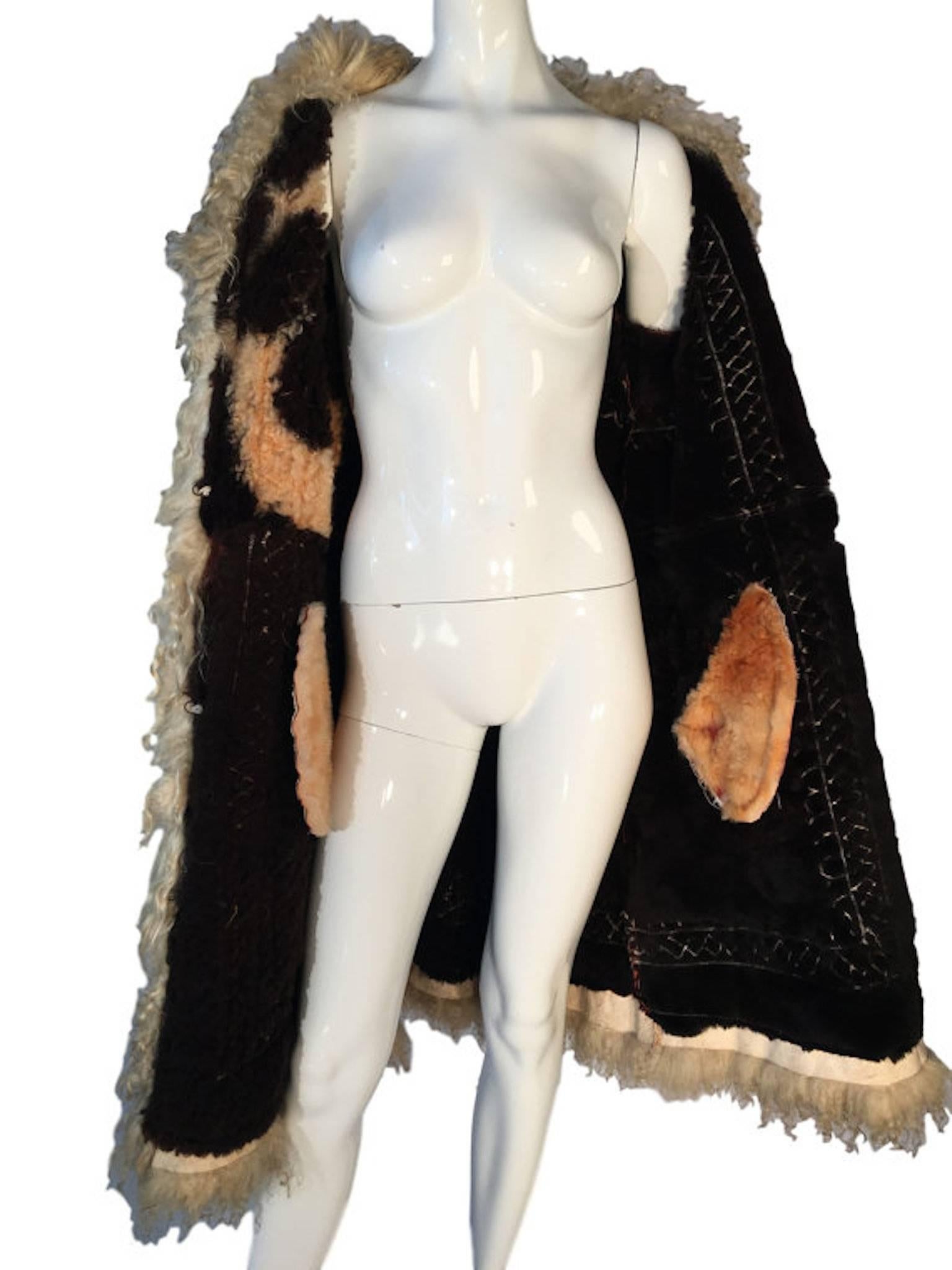 Original 1970's afghan sheepskin and suede coat with embroidery, beautifully lined with sheepskin shearling in different shades, embroidered with flowers and beautiful trim on cuffs opening of coat. Has hook/eye fastening.

Size UK 12-14,