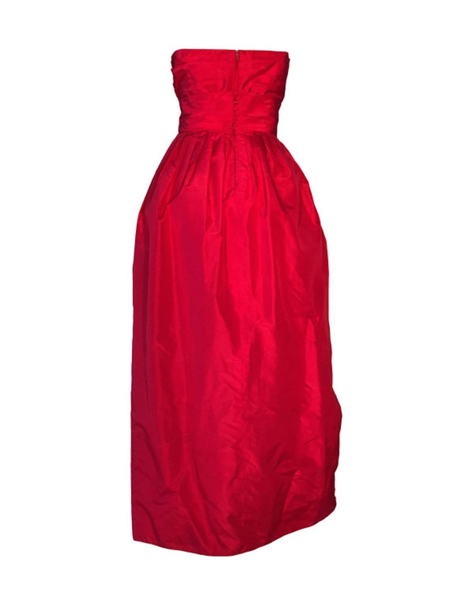 Vintage red taffeta Estevez boned bustier cocktail/evening dress. Lined with chiffon, has button back belt and zip, tulip shaped skirt and fitted waist band.

Size UK 10/12 measuring 18.5 inches across bust, 14.5 inches across waist and 51 inches