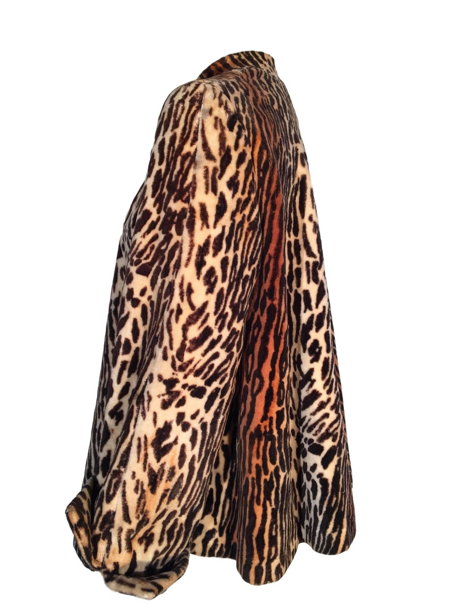 Rebere of Mayfair leopard faux fur coat, swing shape and has structure on the shoulders, lined with a silky crepe like material, the sleeves are wide with turn up cuffs and it has a collarless neck line. 

In excellent condition, the label is coming