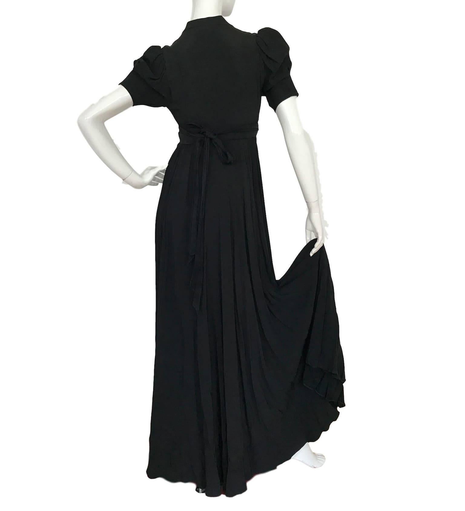 Ossie Clark Quorum black crepe wrap dress. Low cut bust wrap fastening and pleated full skirt. 32 bust 26 waist and 62 inches length. 
Excellent condition with minor pin holes to back and one hook/eye closure missing. 
