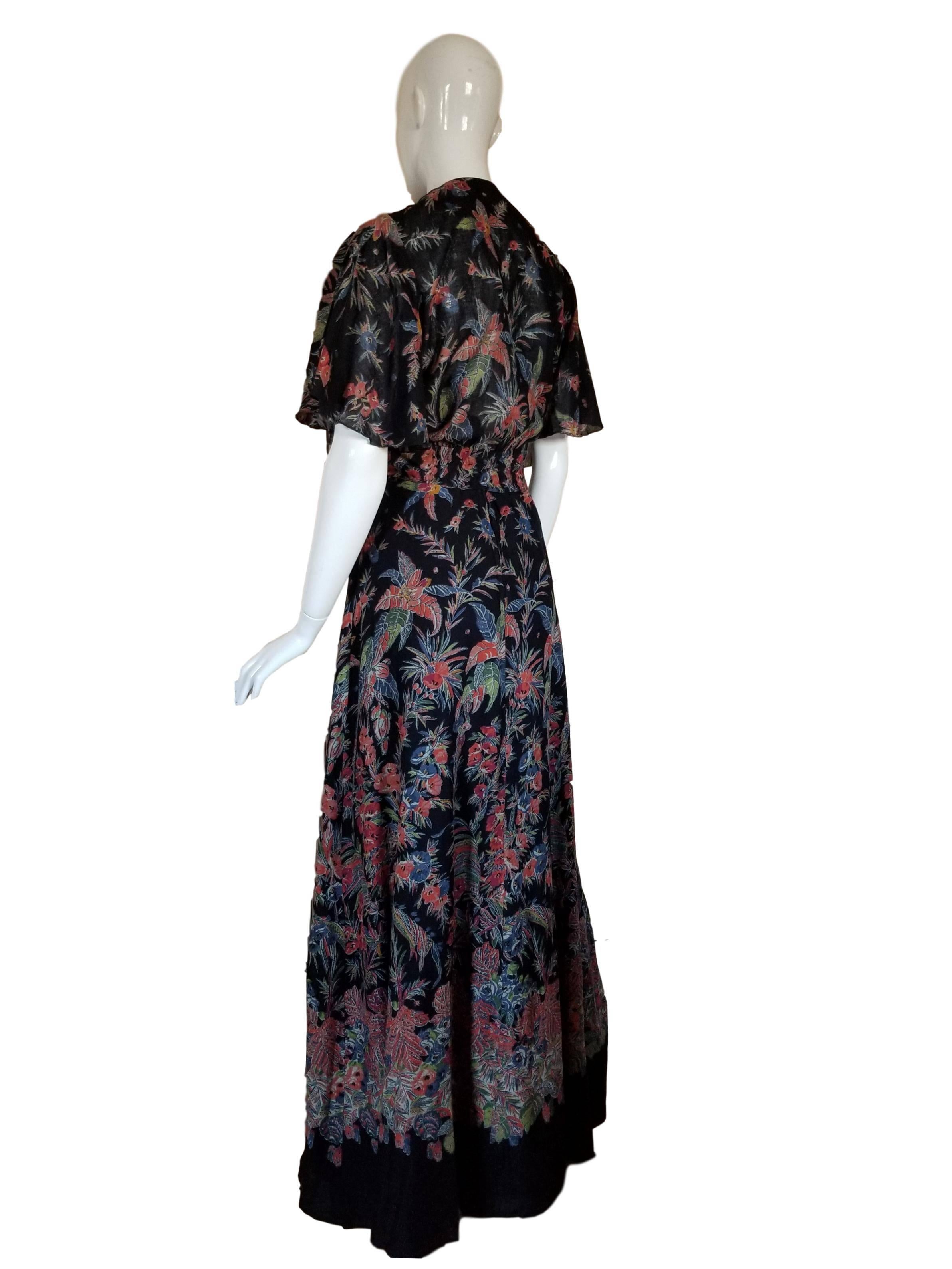 Vintage cotton floral maxi dress by Puszta, with elasticated bust and cross back thin straps. Fastens with a zip and has matching bolero.

Excellent condition.

To fit a UK size 10/12 measures 18-19 inches with stretch across bust, 13-14 inches