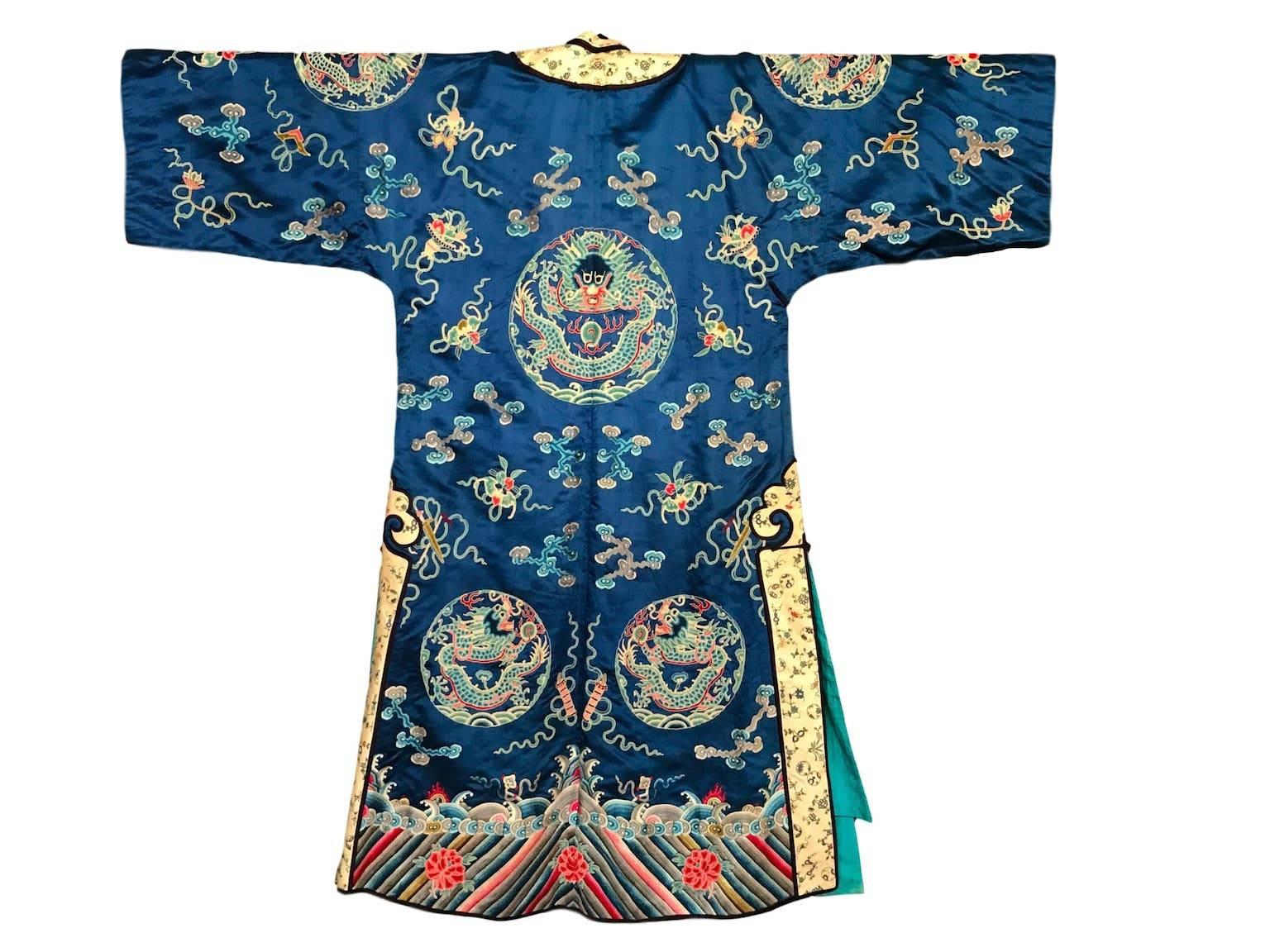 C1910 blue silk satin Chinese Coat with open stitch embroidery has fine silk lining and wide sleeves. 
In excellent condition. 
27 inches across chest. 27 inches across shoulders. 55 inches across whole garment and 54 inches total length