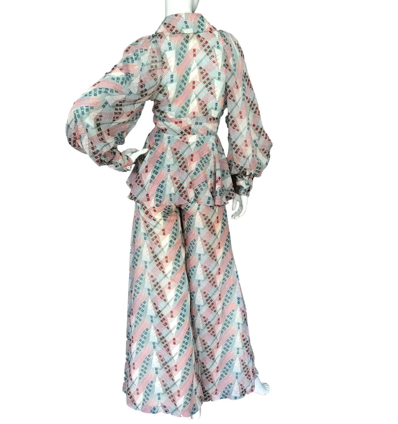 A rare label "Bourgeois" Carnaby Street trouser suit. Wide leg trousers and tie front poet sleeve blouse in a possible Zandra Rhodes print. Made from a light weight cotton or blend. 
Excellent condition.
Measures 32 inch bust and 26 inch