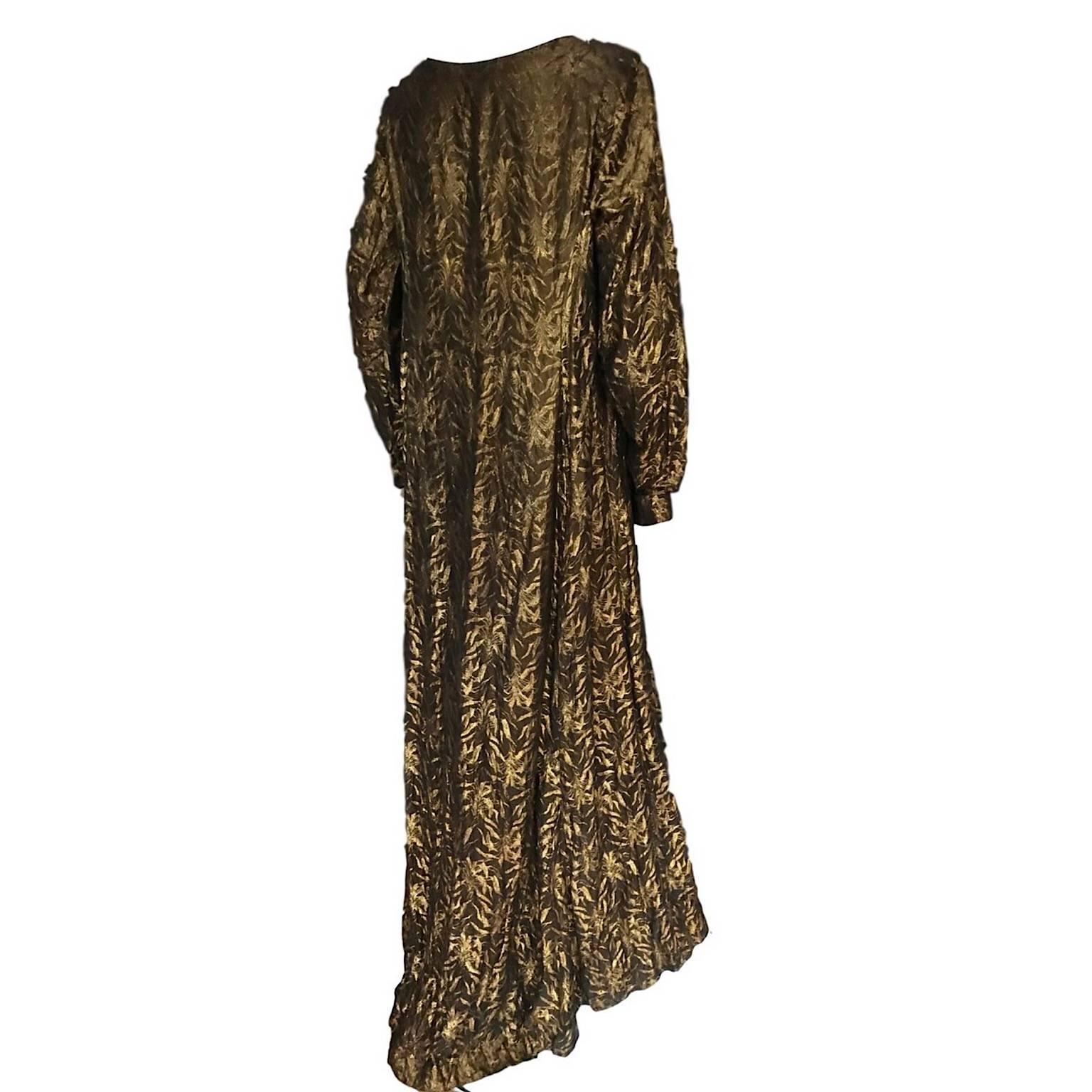 
Harvey Nichols 1930s Gold Lamé damask full length dress, with a repeating leaf design, long fitted sleeves with cuff buttons, slight shoulder pads and a slight train/longer length at back. Inner weight on the front upper bust for the neck line