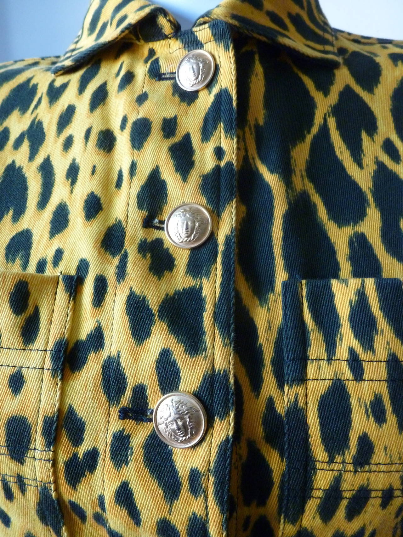 Gianni Versace gold and black animal print cotton jacket from the Spring 1992 collection. The jacket features two large pockets at the bust and is secured at the front and the cuffs by a series of gilt-tone metal Medusa embossed buttons.

Marked