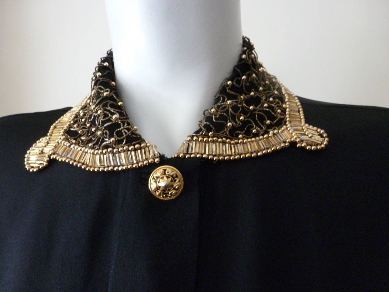 A beautiful Gianni Versace Couture black silk beaded and embroidered sleeveless evening blouse from the Fall 1992 Bondage collection. The collar is embroidered with gilt purl thread and is punctuated with gold-tone metal studs.

Marked an Italian