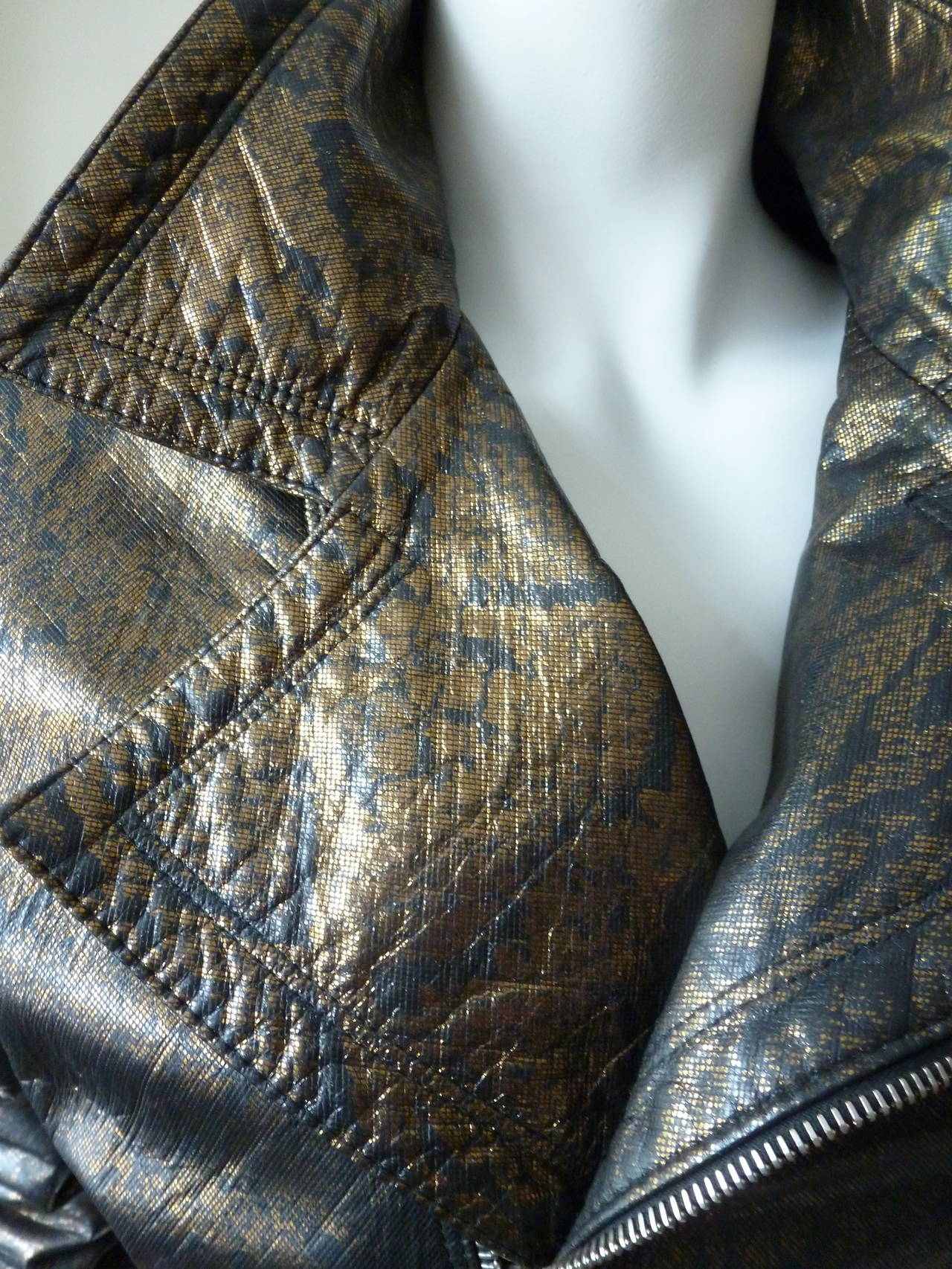 Rare Gianni Versace black and bronze metallic python skin effect cropped leather biker jacket from the Fall 1994 collection. The jacket features metal Medusa embossed hardware, together with Greca belt detailing. The jacket is fully