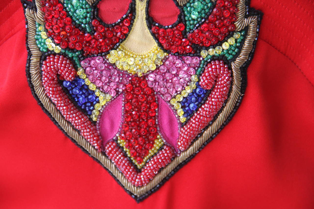 A beautiful and rare Gianni Versace red silk satin hand embroidered and beaded cocktail dress from the Spring 1990 Istante collection.

The dress has coloured bead, purl wire and metal thread hand embroidered bust decoration.

Marked an Italian