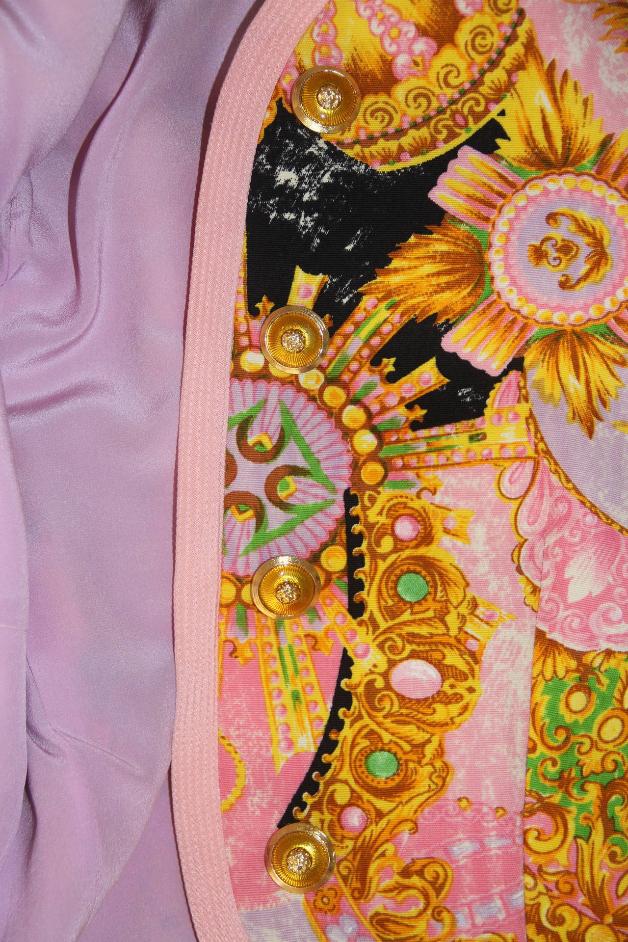 A very rare Atelier Versace suit, featuring a coronet and tiara polychrome print from the Spring 1992 Haute Couture collection, shown at The Ritz in Paris.

The ensemble consists of a short collarless jacket in shades of pink, mauve, green, gold